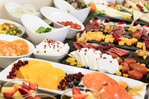 a table filled with different types of cheese and fruit at Nura Santa Ponsa & Spa in Santa Ponsa