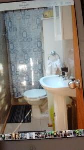 a bathroom with a sink and a toilet at Complejo Cabañas Pétalos in Villarrica