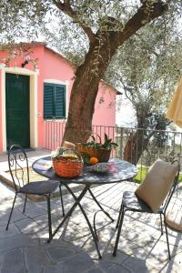 une table et des chaises sous un arbre sur une terrasse dans l'établissement La Torretta, à Imperia