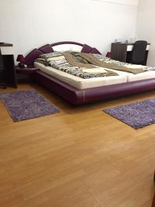 a bed sitting on top of a wooden floor with two rugs at City Bridge Guest House in Bihać