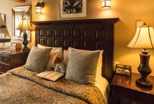 a teddy bear sitting on a bed with a book at Moonstone Cottages in Cambria