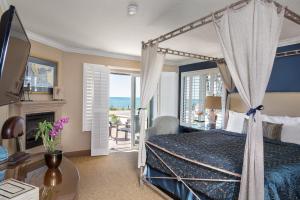 坎布里亞的住宿－藍海豚酒店，一间卧室设有一张天蓬床和一个壁炉