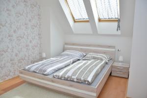 a bed in a white room with two pillows at Apartmá Kateřina Velké Losiny in Velké Losiny