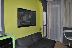 a living room with a couch and a flat screen tv at Landmark am Kracauerplatz in Berlin