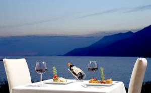 a table with two glasses of wine and food on it at Lukka Exclusive Hotel – Adult Only +12 in Kaş