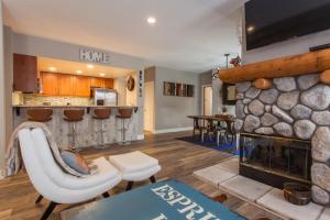a living room with a stone fireplace and a kitchen at Snowcreek #881 - Phase V in Mammoth Lakes