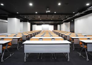 a classroom with rows of tables and chairs at HOTEL MYSTAYS Ochanomizu Conference Center in Tokyo