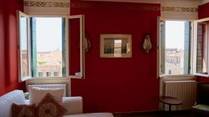 a living room with red walls and two windows at Ca Arsenale in Venice