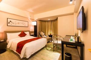 a hotel room with a bed and a desk at Chambery Hotel in Zhuhai