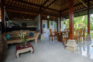 a living room with a table and a dining room at Asung Guesthouse in Canggu