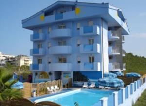 a building with a swimming pool next to a resort at Residence Blumarine in Giulianova