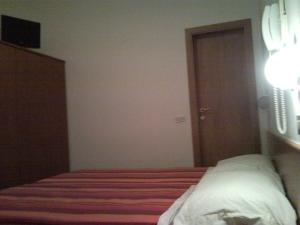 een slaapkamer met een bed en een deur naar een kamer bij Hotel Trinidad in Rimini