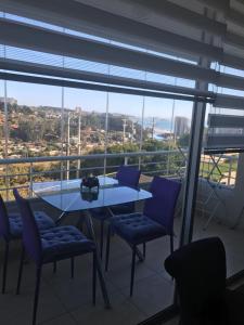 un tavolo e delle sedie in una stanza con una grande finestra di Algarrobo, Laguna bahí­a departamento 1303 & 302 ad Algarrobo