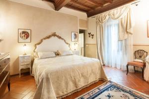 Un dormitorio con una cama grande y una ventana en LA FINESTRA SUL BORGO Dimora Storica, en Laterina