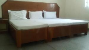 uma cama com uma cabeceira em madeira e 2 almofadas em Central Mina Residency- only for Indians em Chennai