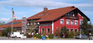 un bâtiment rouge avec une camionnette blanche garée devant. dans l'établissement Hotel Sonnenhof, à Thannhausen