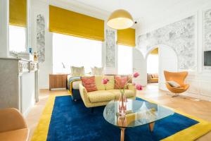 ein Wohnzimmer mit einem Sofa und einem Tisch in der Unterkunft Smartflats - Raphael Suites in Antwerpen