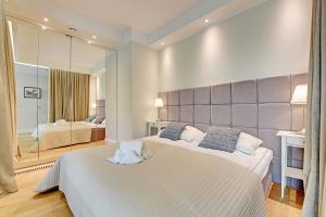 ソポトにあるGrand Apartments Wave- Na Faliのベッドルーム1室(ベッド2台、大きな鏡付)