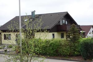 a yellow house with a black roof at Wirtsbauers-Ferienwohnung in Merklingen