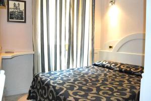- une chambre avec un lit et une grande fenêtre dans l'établissement Hotel Nardizzi Americana, à Rome