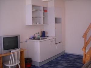 a small kitchen with a sink and a tv at Hotel Gedser Apartments in Gedser