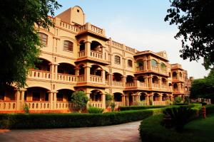 a large building with a pathway in front of it at MVT Guesthouse & Restaurant in Vrindāvan