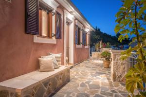 una pasarela de piedra con un banco frente a un edificio en Ninemia Villa Zakinthos en Zakynthos