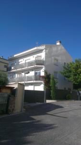 un edificio blanco con un balcón en el lateral. en Apartaments Josep Pla, en Roses