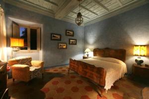 een slaapkamer met een groot bed en een stoel bij Appartamenti Lais in Sipicciano in Sipicciano