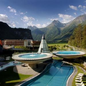 two large swimming pools with mountains in the background at Ferienwohnung Familie Höfler in Längenfeld