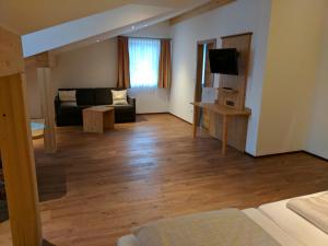 ein Wohnzimmer mit einem Sofa und einem TV in der Unterkunft Gasthaus Weingast in Bad Feilnbach