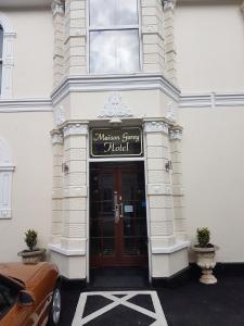 un bâtiment avec une porte munie d'un panneau. dans l'établissement Maison Gorey Hotel, à Grouville