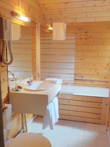 a bathroom with a sink and a tub at Hôtel Engilberge in Ailefroide