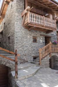 a stone building with a staircase and a balcony at Vecchio Fienile in Aosta