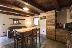 a kitchen with a wooden table in a room at Vecchio Fienile in Aosta