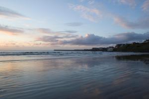 
a beach scene with the sun setting at Ceol na Mara Holiday Homes - Cois Tra & Cor na dTonn in Enniscrone
