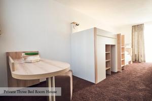 a room with a table and a bed room house at Private Holiday Homes by Solaria in Davos