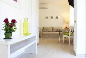 una sala de estar con un jarrón de flores en un mostrador en Taonasi Mazzeo Apartment, en Mazzeo