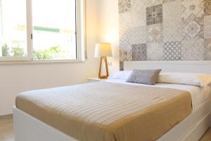 - une chambre avec un grand lit et une fenêtre dans l'établissement Taonasi Mazzeo Apartment, à Mazzeo