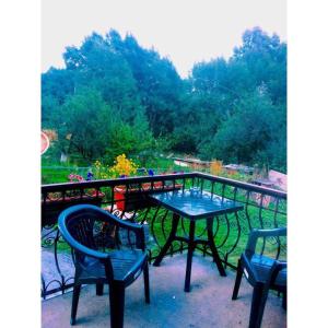 a table and two chairs on a balcony at Lia&Ramaz Guest House in Kazbegi