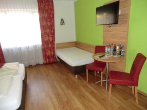 a small room with a bed and a table and a tv at Hotel Pension Haydn in Munich