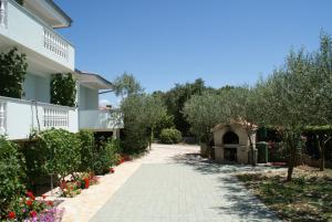 a walkway in front of a house with flowers at Apartments Jurjevic in Petrcane