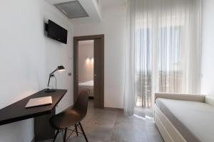 a bedroom with a desk and a bed and a bed and a bed at Hotel Eden in Alba Adriatica