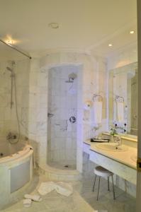 a bathroom with a shower and a sink and a tub at Royal Garden Palace - Families and Couples in Midoun
