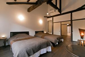 a bedroom with two beds and a table and a table at Hashiba-an in Kanazawa