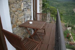 a wooden table and chairs on a balcony at Bed & Breakfast Triora Medievale in Triora