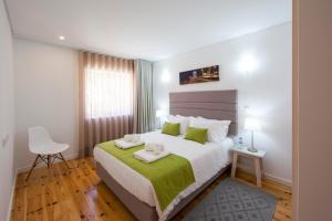 1 dormitorio con 1 cama grande con manta verde en FishermenApartments - Santos 4E, en Lisboa
