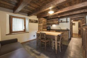 a kitchen with a large wooden table and chairs at Vecchio Fienile in Aosta