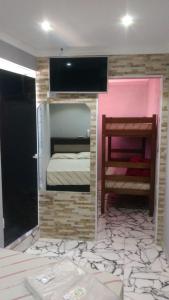 a room with a bed and a tv on a wall at Hotel Flor da Vila Mariana in Sao Paulo