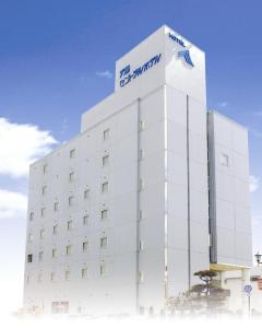 a white building with a sign on it at Tendo Central Hotel in Tendo